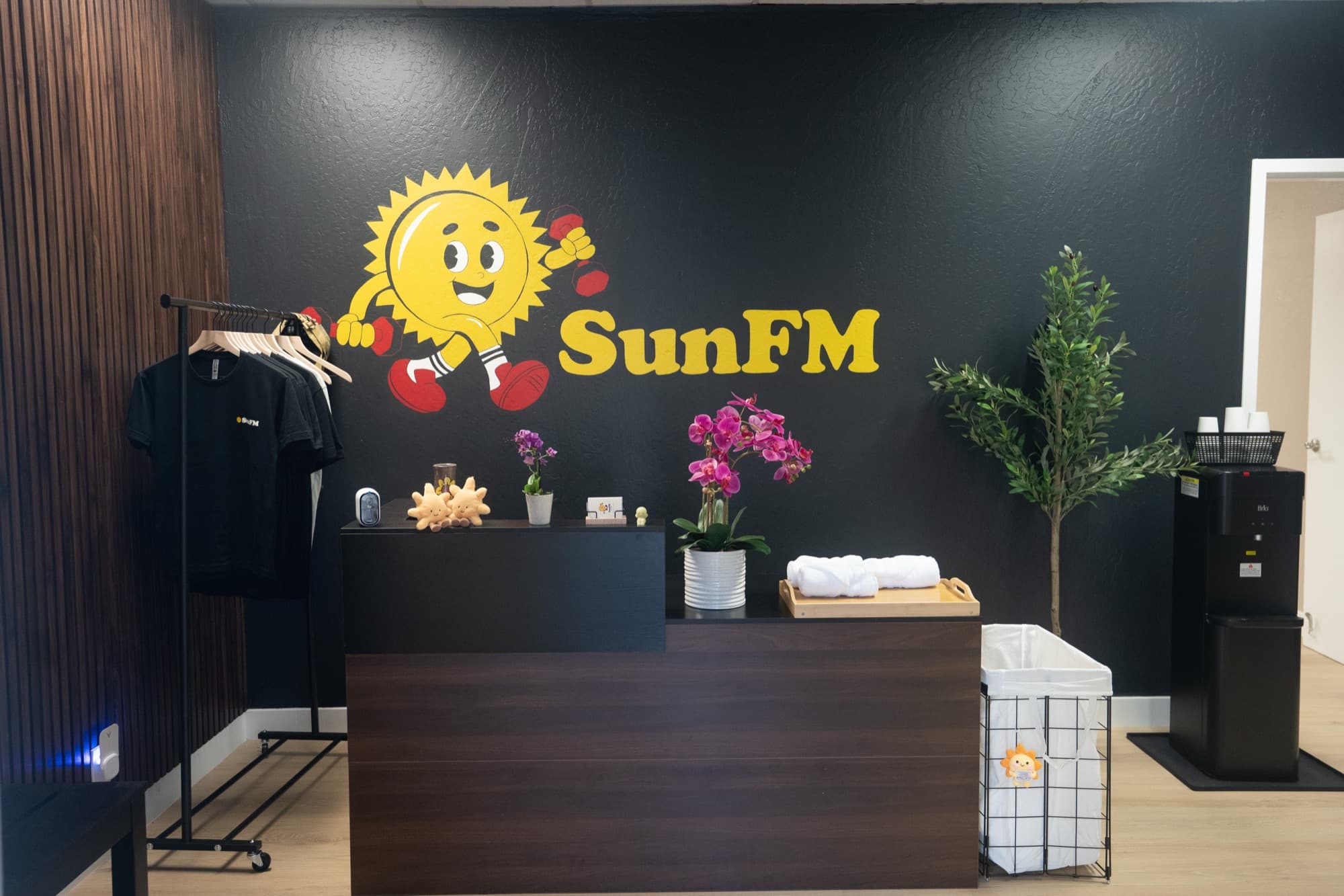 Front desk and SunFM logo wall at the San Jose studio